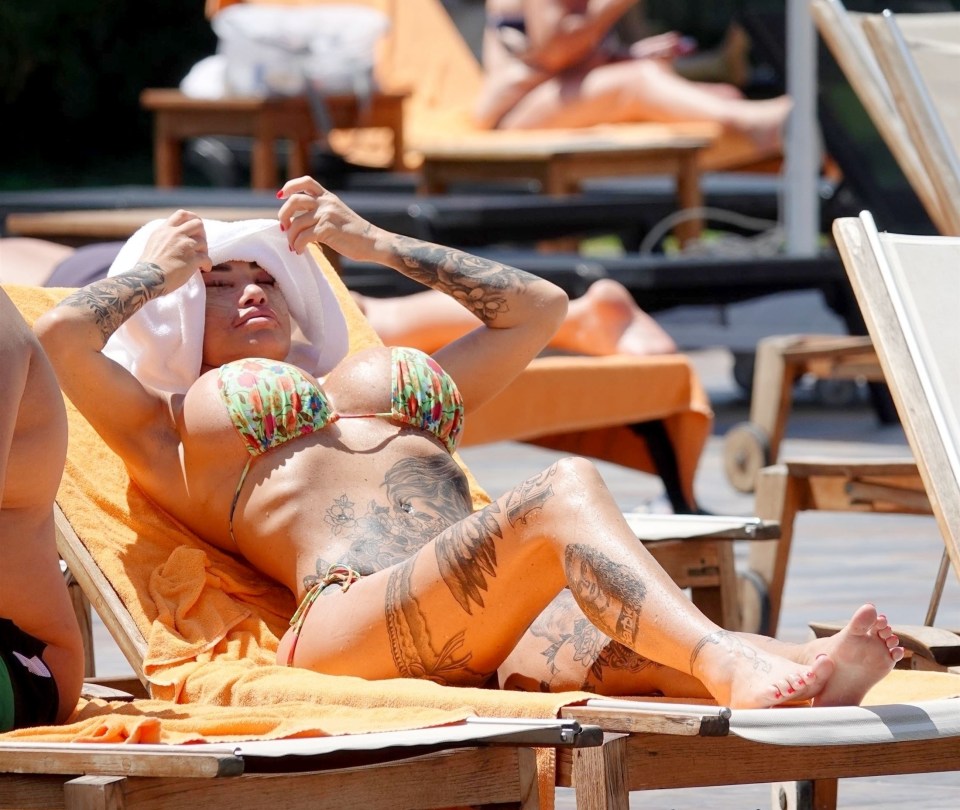 a woman in a bikini is laying on a beach chair