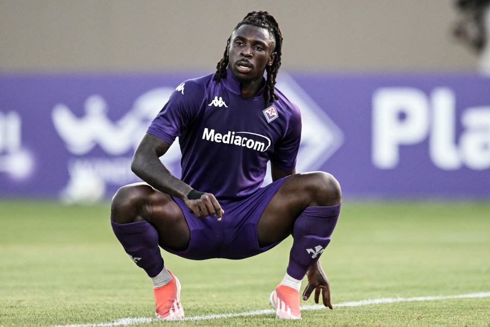 a soccer player wearing a purple mediacom jersey squats on the field