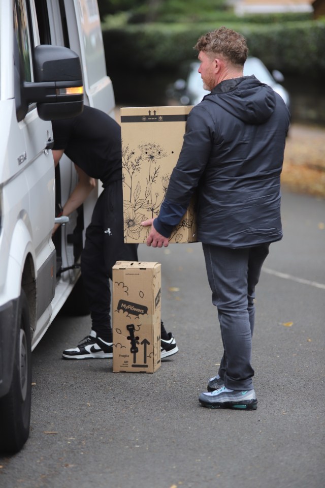 a man carrying a box that says ' flowers ' on it