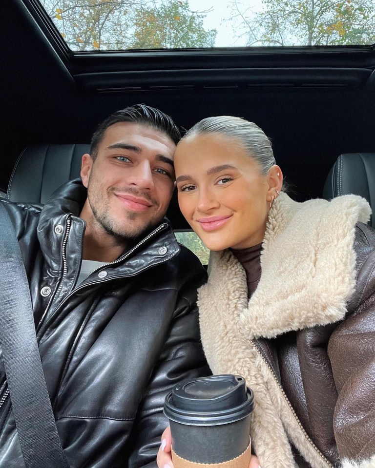 a man and a woman are posing for a picture in a car