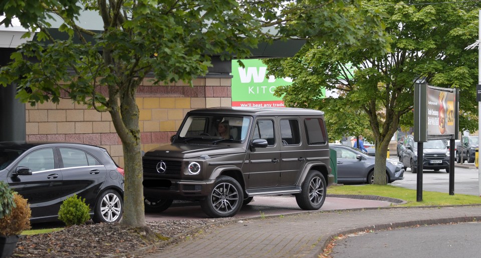 a car is parked in front of a building that says w kitchen