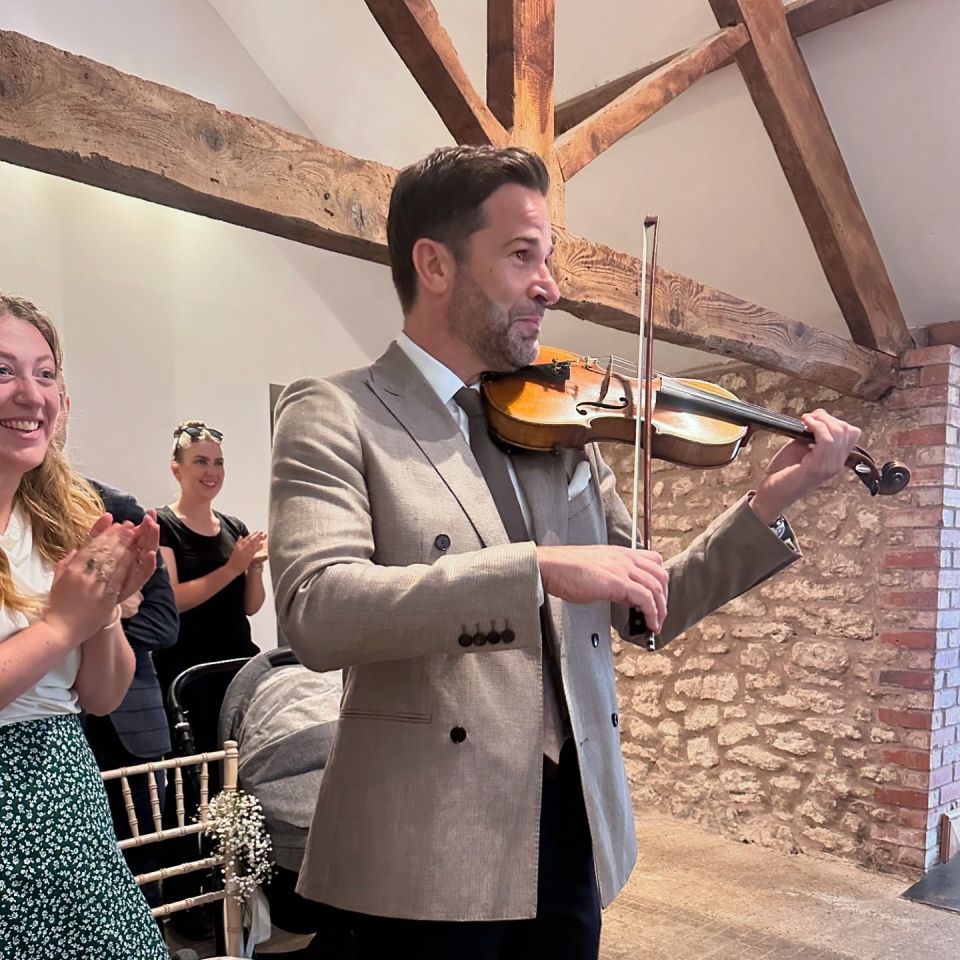 a man in a suit is playing a violin