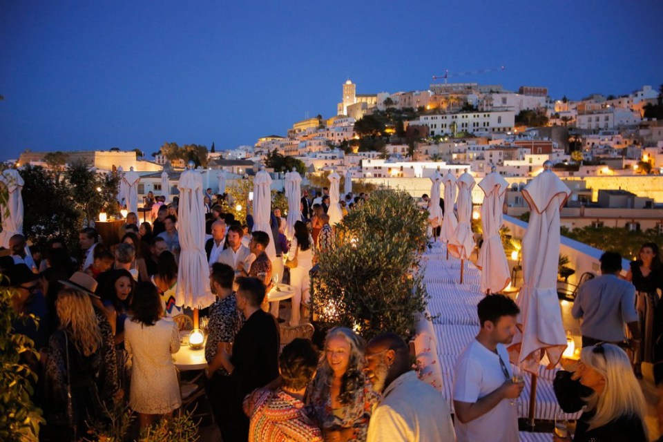 a crowd of people are gathered on a rooftop at night