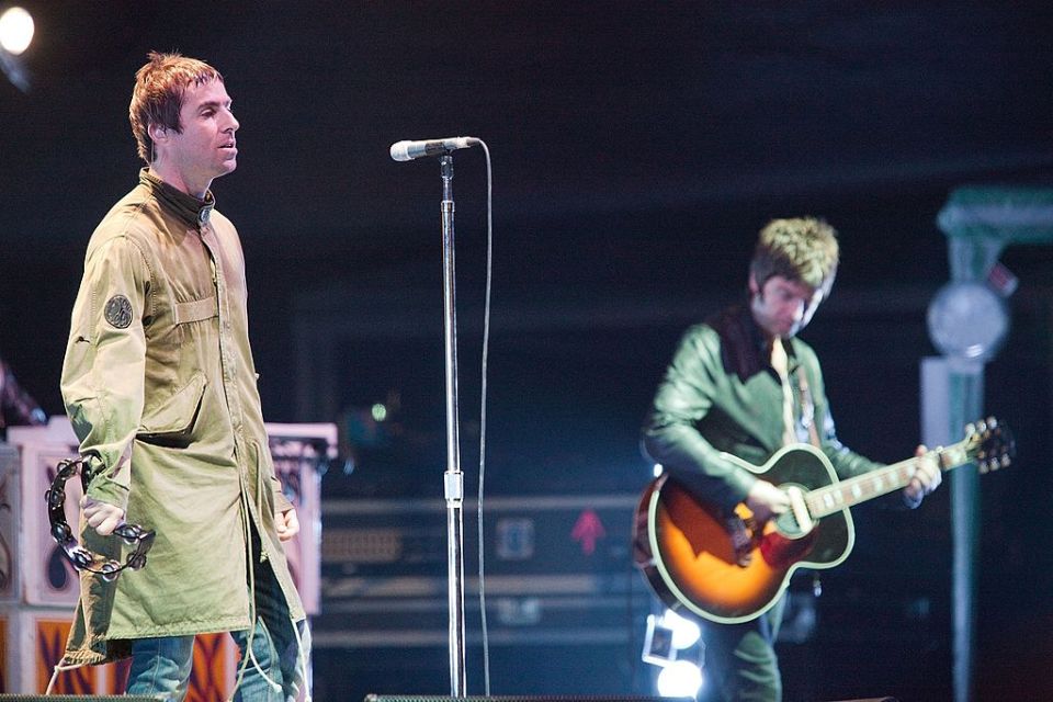 a man singing into a microphone while another man plays a guitar