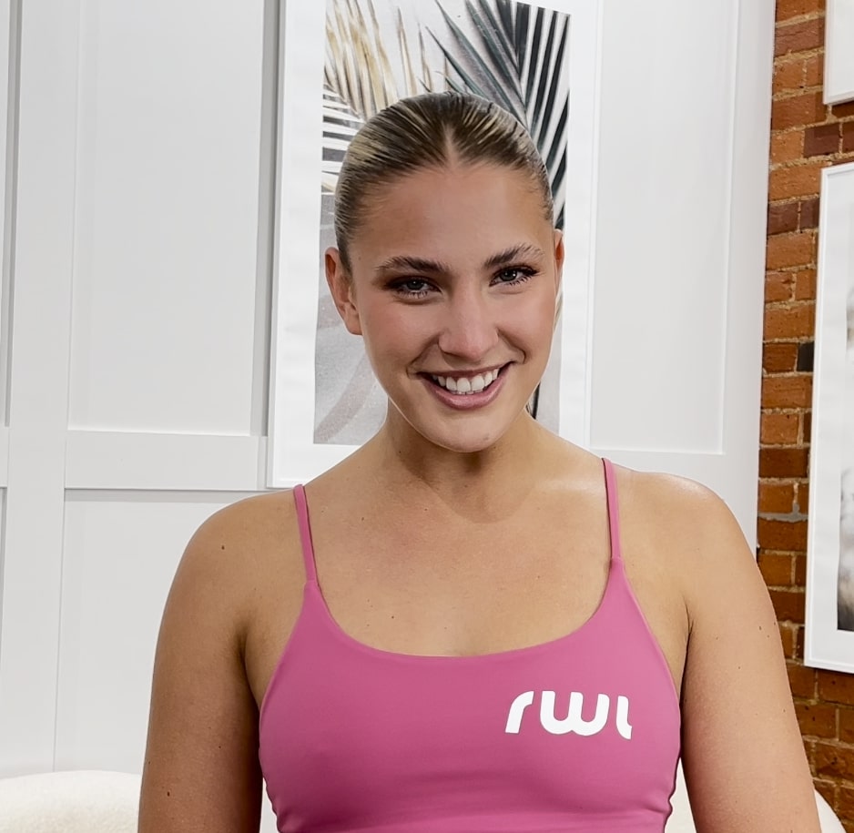 a woman wearing a pink tank top with the letter m on it