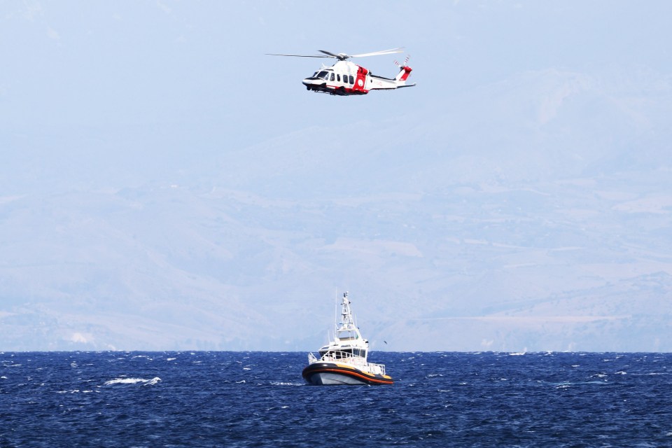 a helicopter is flying over a boat in the ocean