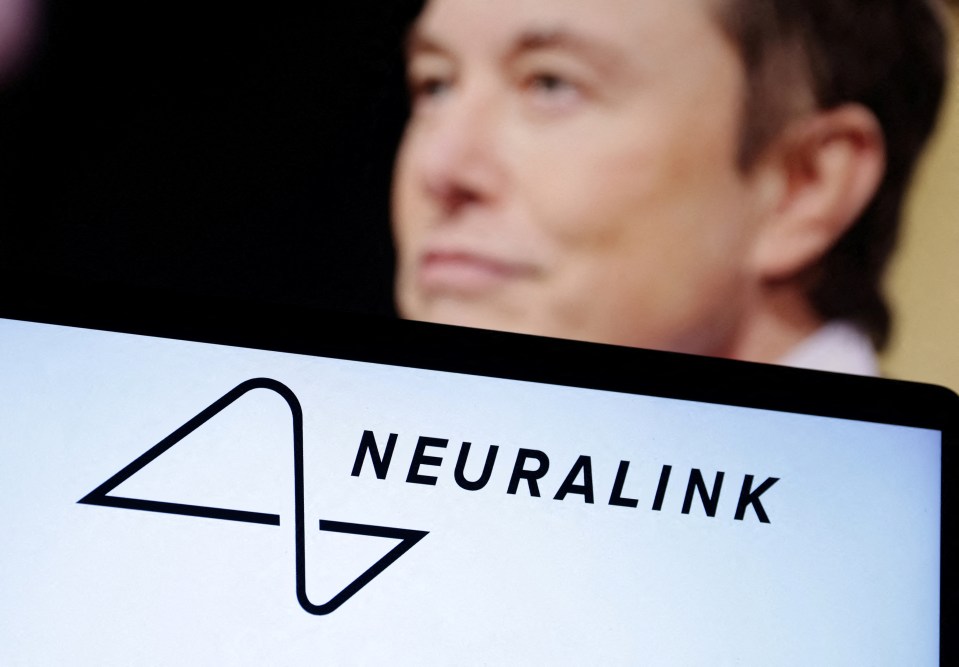 a man stands in front of a screen that says neuralink