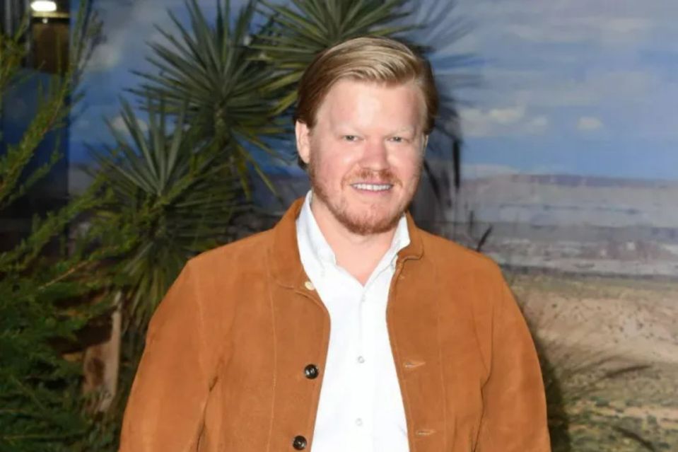 a man with a beard is wearing a brown jacket and a white shirt