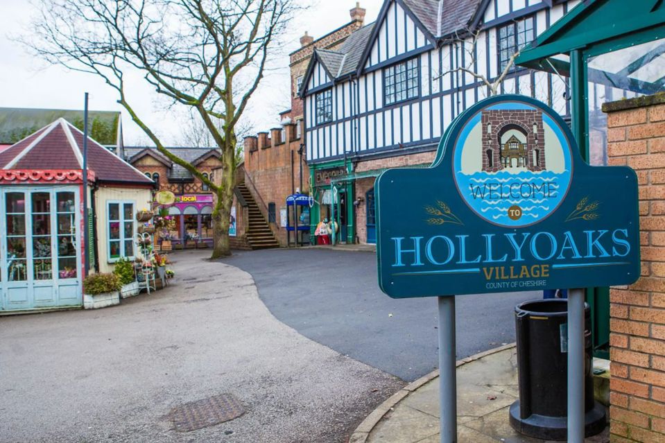 a sign for hollyoaks village in the county of cheshire