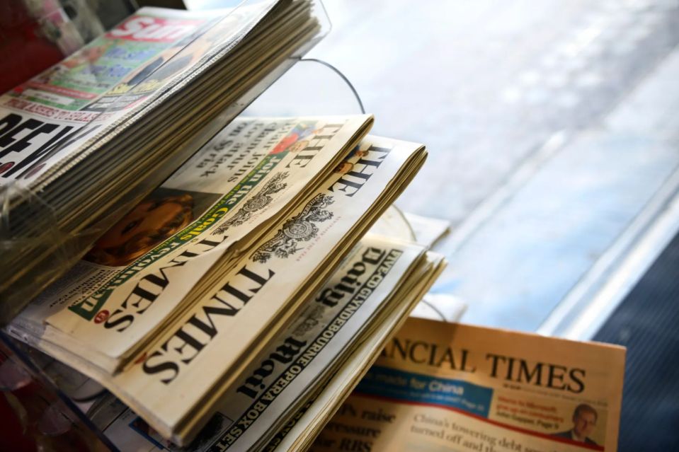 a stack of newspapers including the daily mail and the times