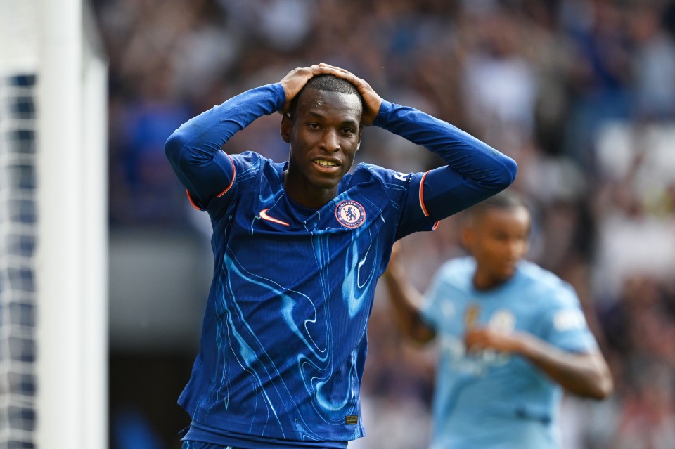 a soccer player wearing a blue shirt with the chelsea logo on it