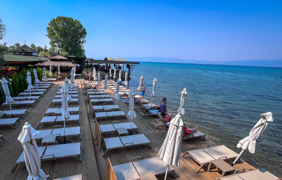 a beach with lots of chairs and umbrellas