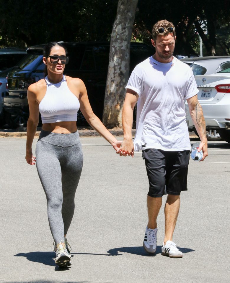 a man and a woman hold hands in a parking lot