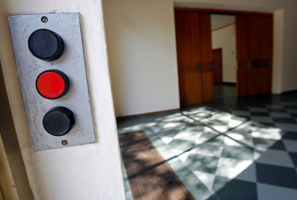 three buttons on a wall one of which is red