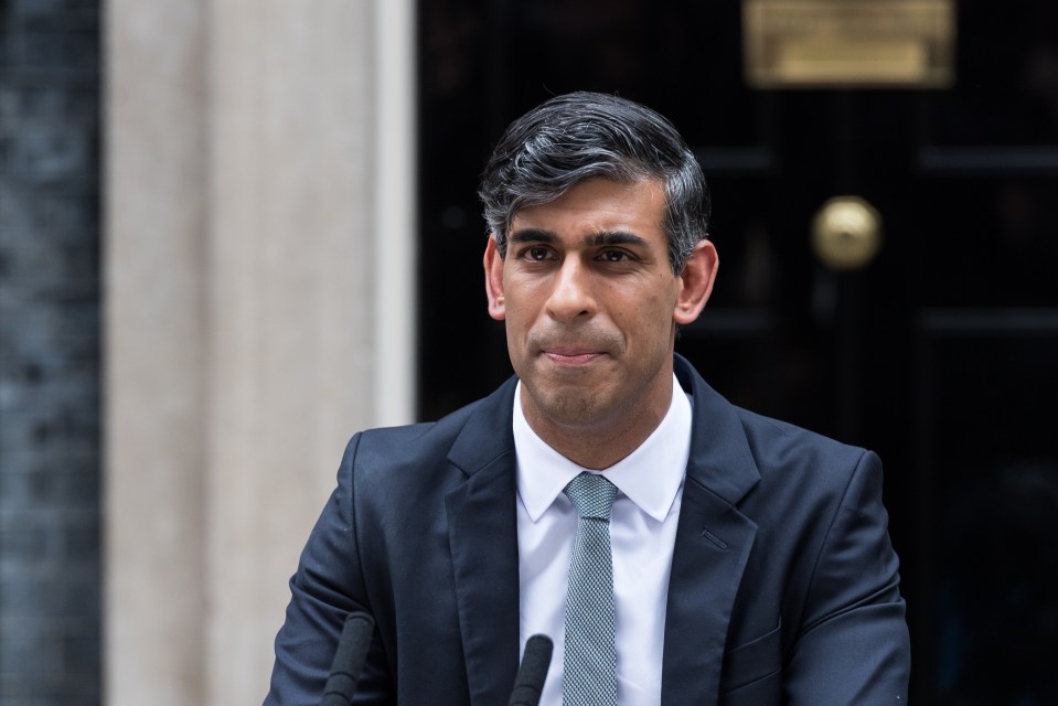 a man in a suit and tie stands in front of two microphones