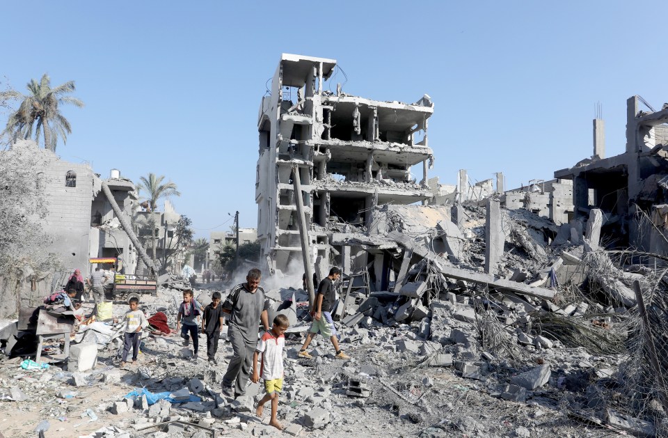 a group of people are walking through a ruined city