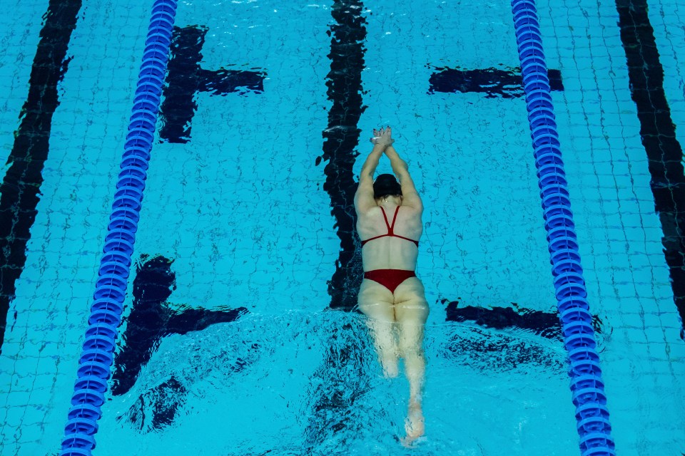 a woman in a red bikini is diving into a swimming pool