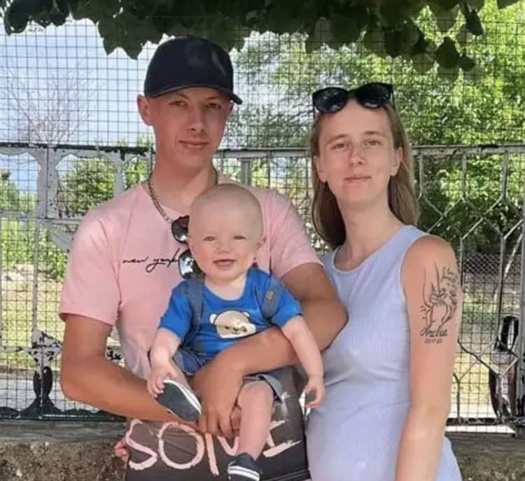 a man and a woman are posing for a picture with a baby .