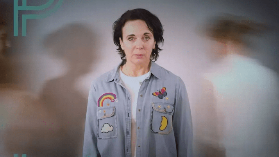 a woman wearing a denim shirt with patches on it