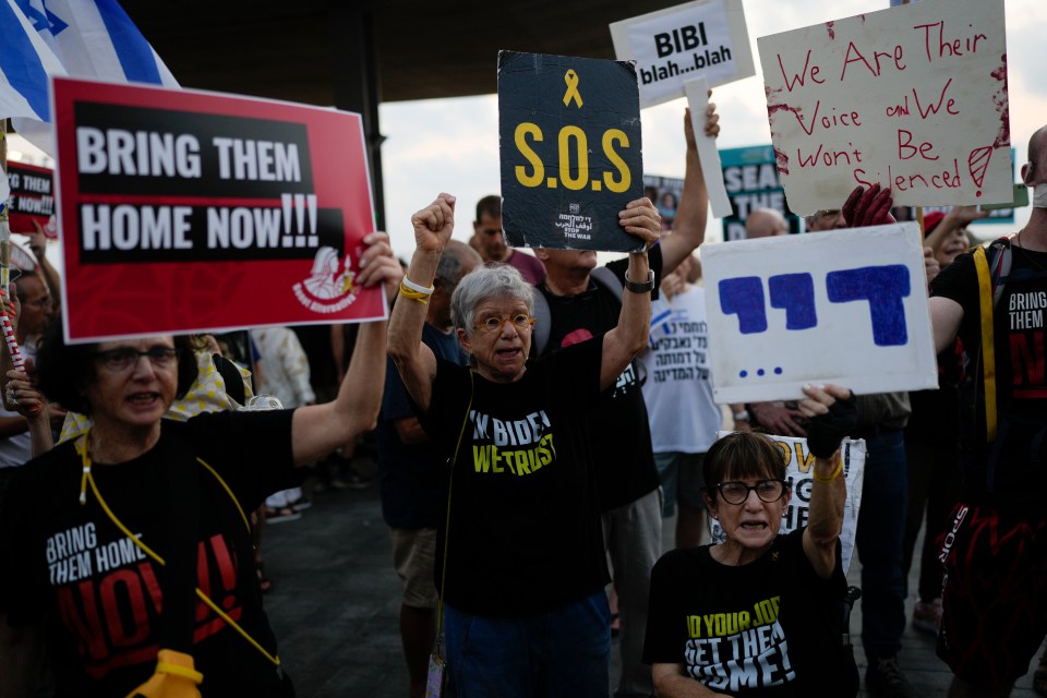 a woman holding a sign that says bring them home now