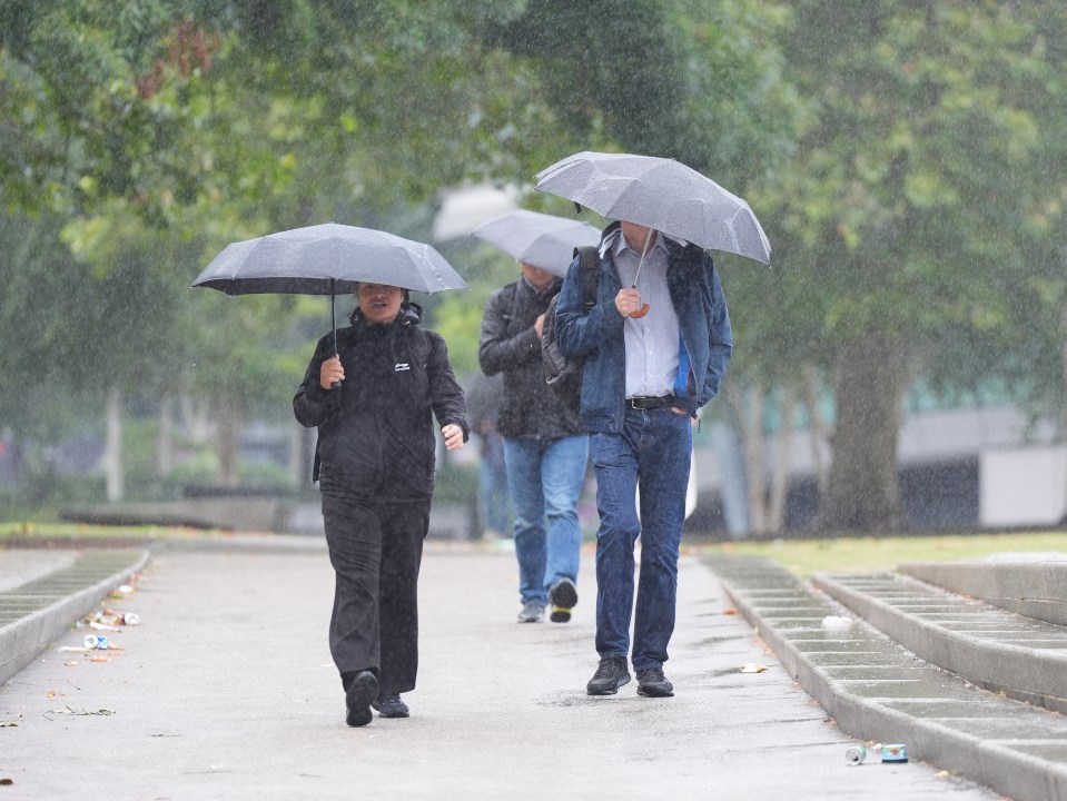 People braving the wet and windy conditions near Tower Bridge in London