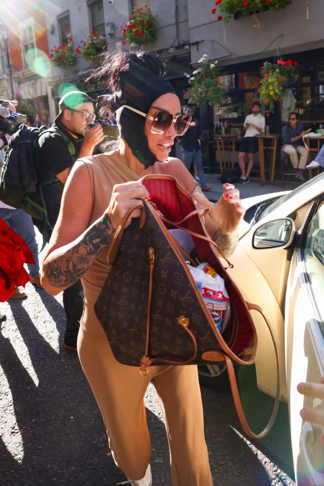 a woman carrying a large louis vuitton bag