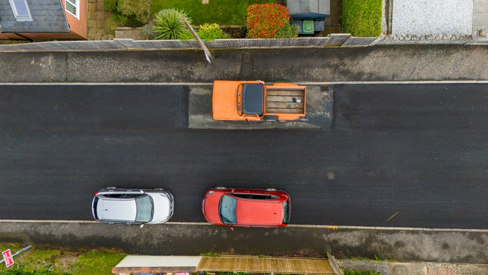 a red car is parked next to a white car