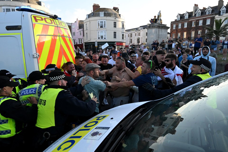 Police officers face off with protesters in Weymouth