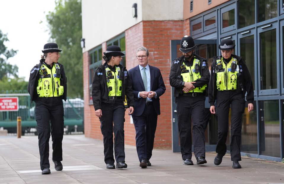 a group of police officers are walking in front of a building