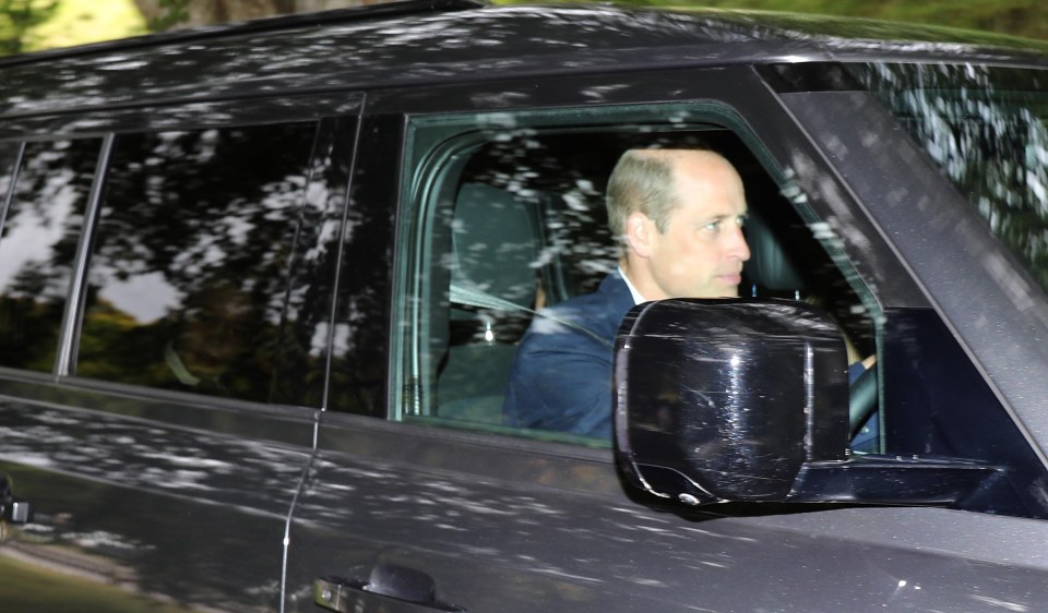 a man in a suit sits in the driver 's seat of a car