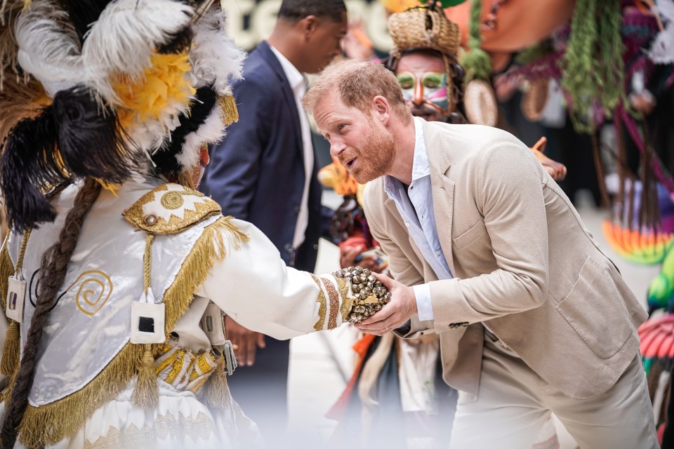 The Duke of Sussex greets a performing artist during the welcome presentation