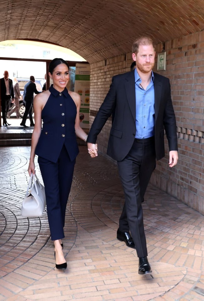 Harry tows Meghan along by the hand as they make their entrance in Colombia this morning