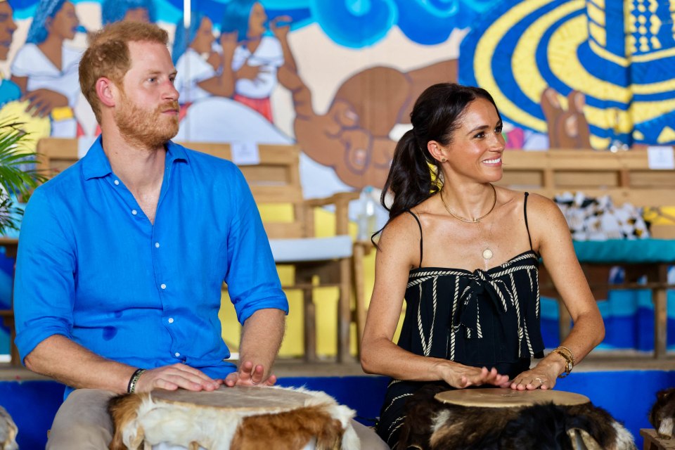 a man and a woman are playing drums in front of a mural