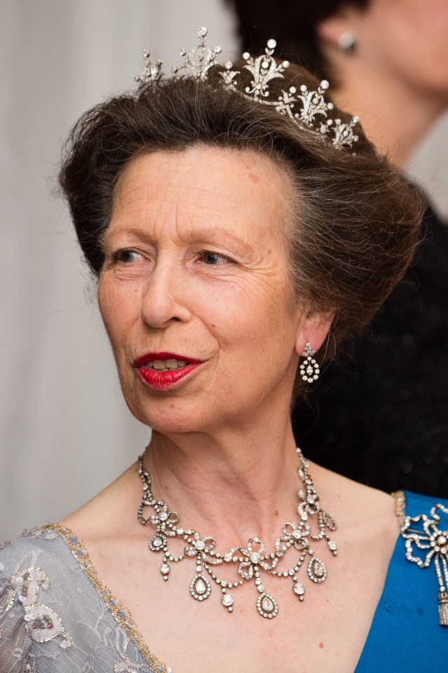 a woman wearing a necklace and earrings with a tiara on her head