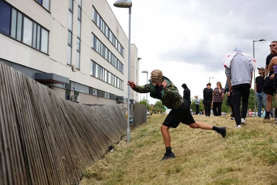 A far right yob throws a stone at the hotel in Rotherham