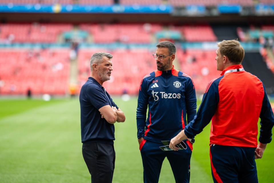 three men standing on a soccer field with one wearing a tezos shirt