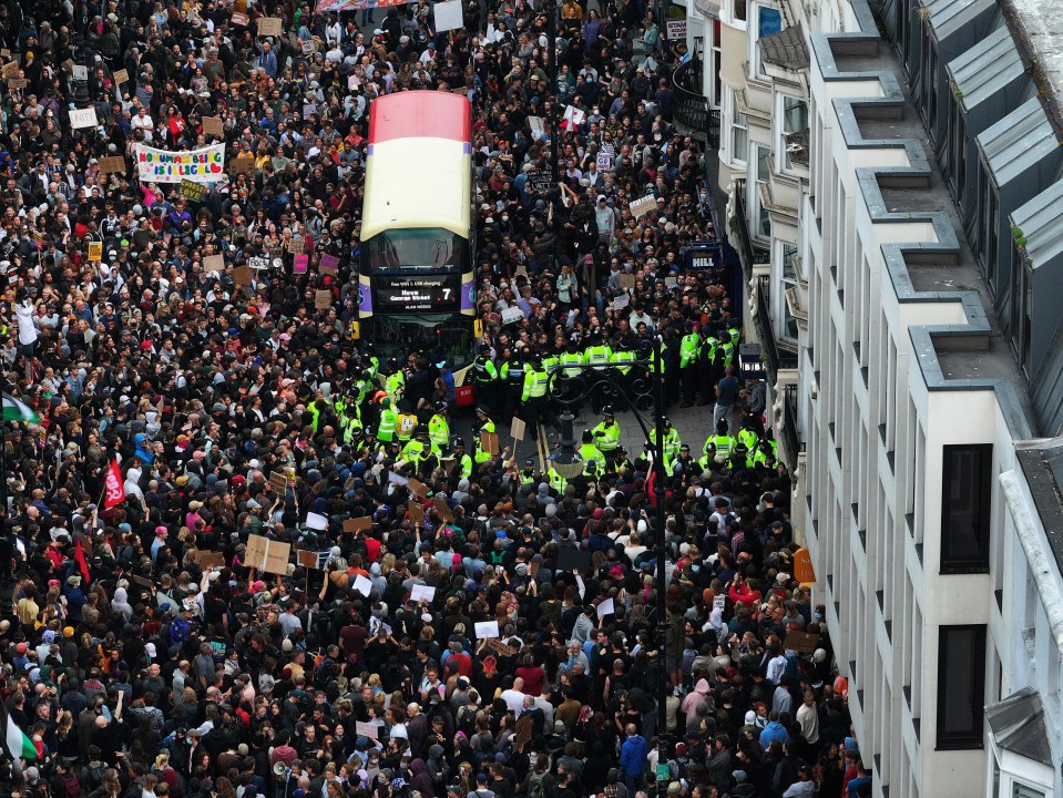 a large crowd of people are gathered on a street with a sign that says ' freedom ' on it