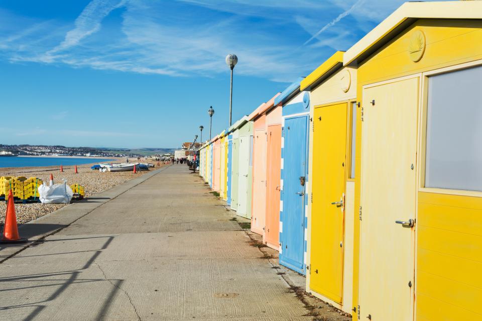 a row of brightly colored beach huts on a sunny day