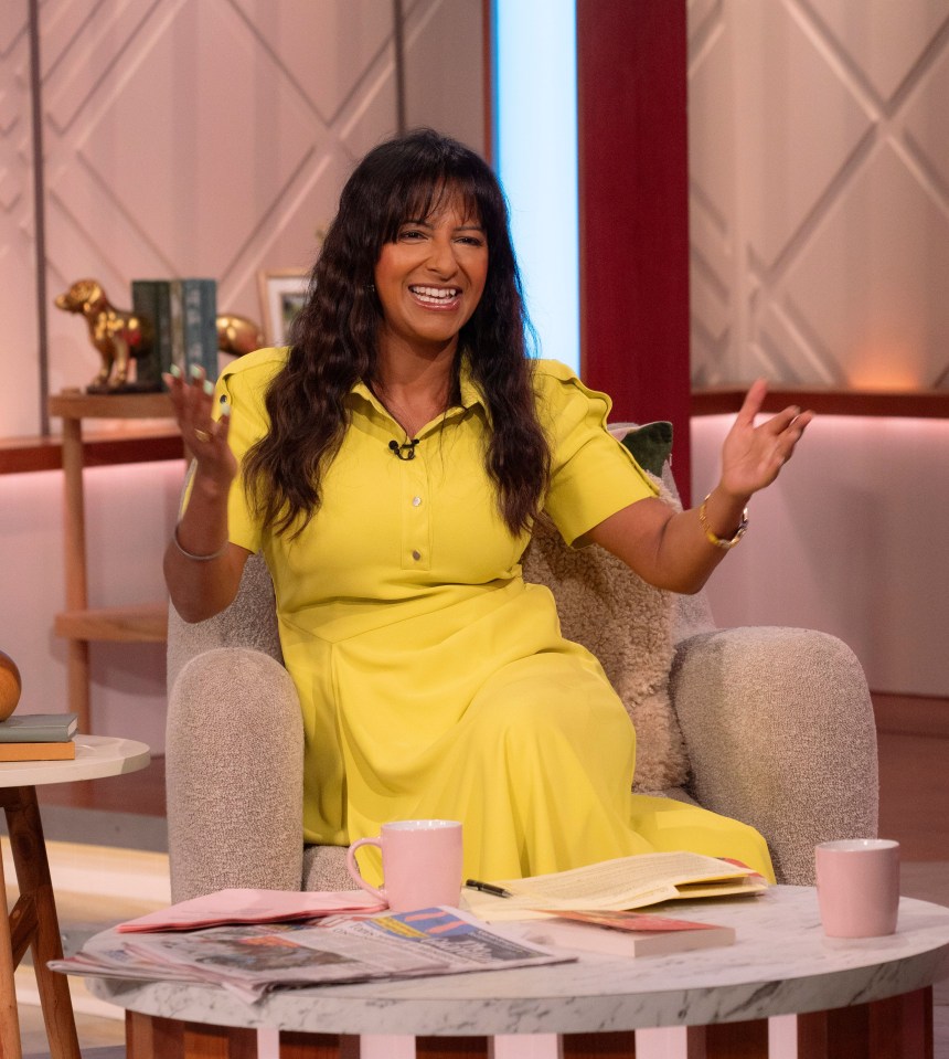 a woman in a yellow dress sits in a chair with her arms outstretched