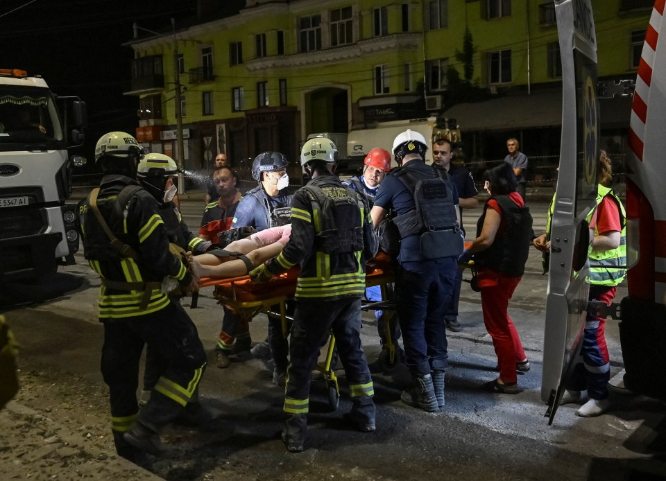 Rescuers and medical workers treat a wounded local resident