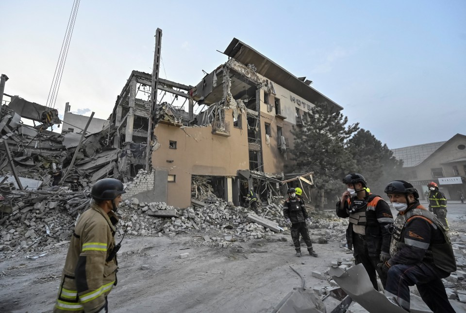 Rescuers stand at a site of a Russian missile strike on the Aurora Hotel in Kryvyi Rih, near where Mr ­Zelensky lived