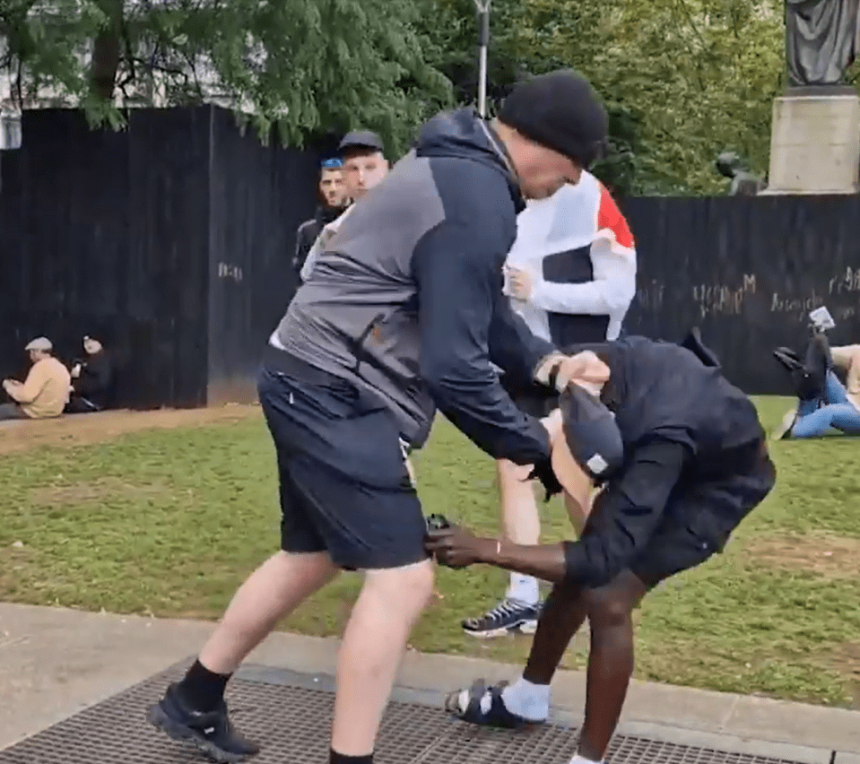 a man in a grey jacket is standing next to a man in black shorts