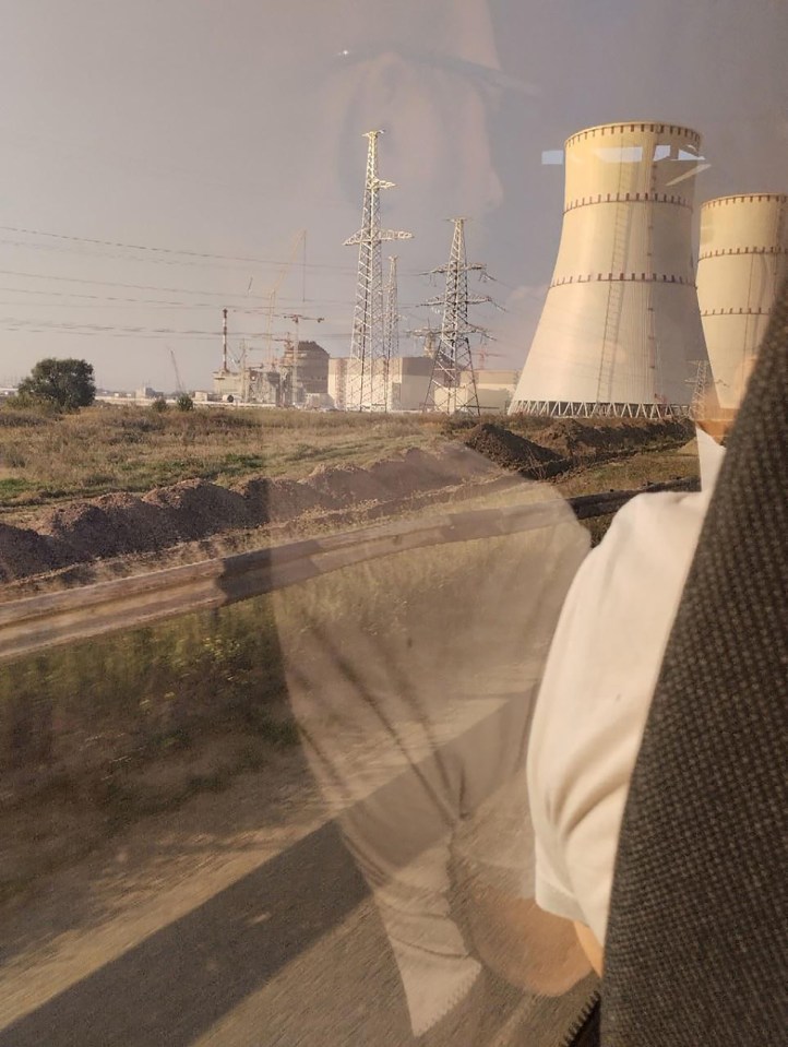 a person looking out a window at a power plant