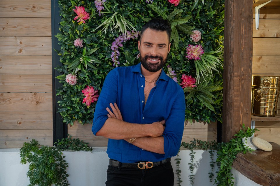 a man in a blue shirt with the letter ch on his belt