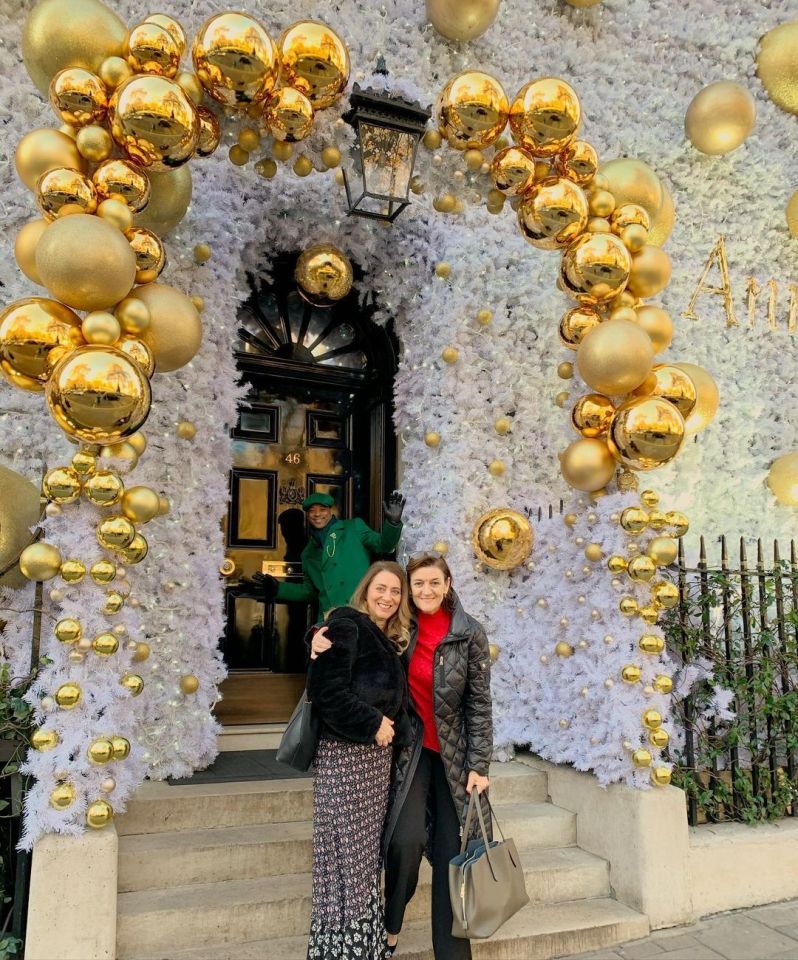 two women standing in front of a building that has the number 40 on it