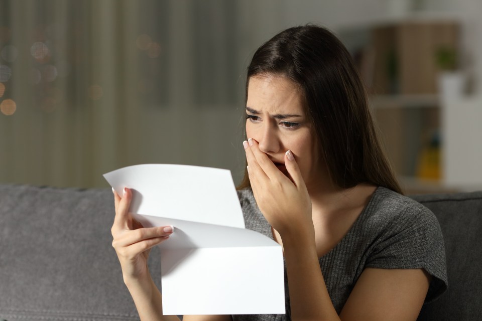 a woman is crying while holding a piece of paper