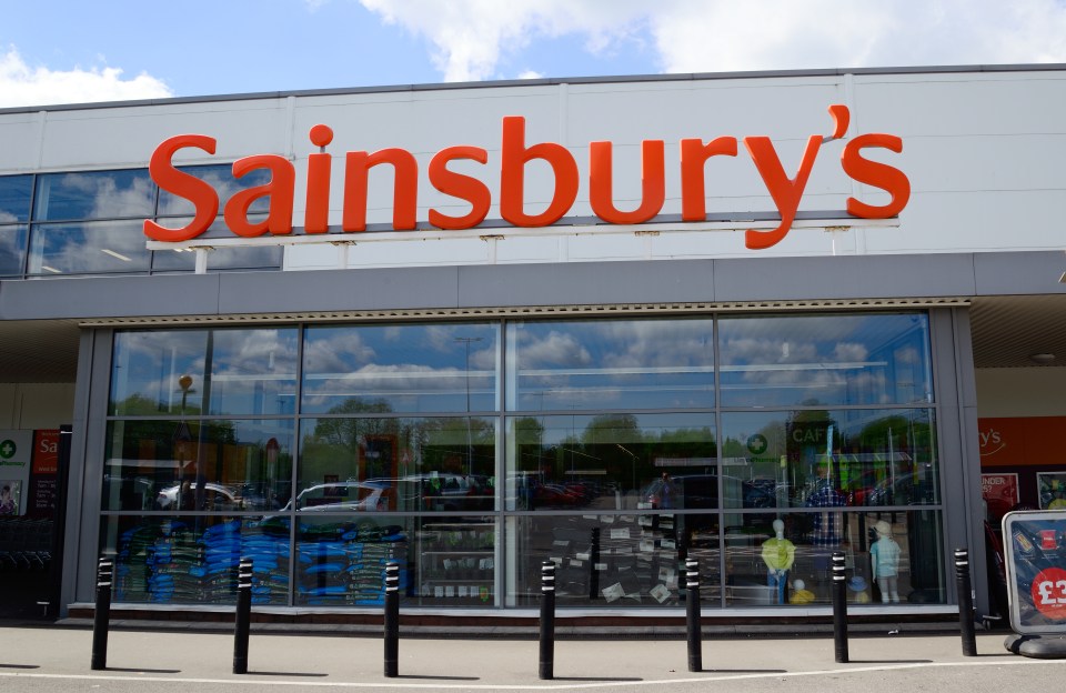 a sainsbury 's store with a large orange sign