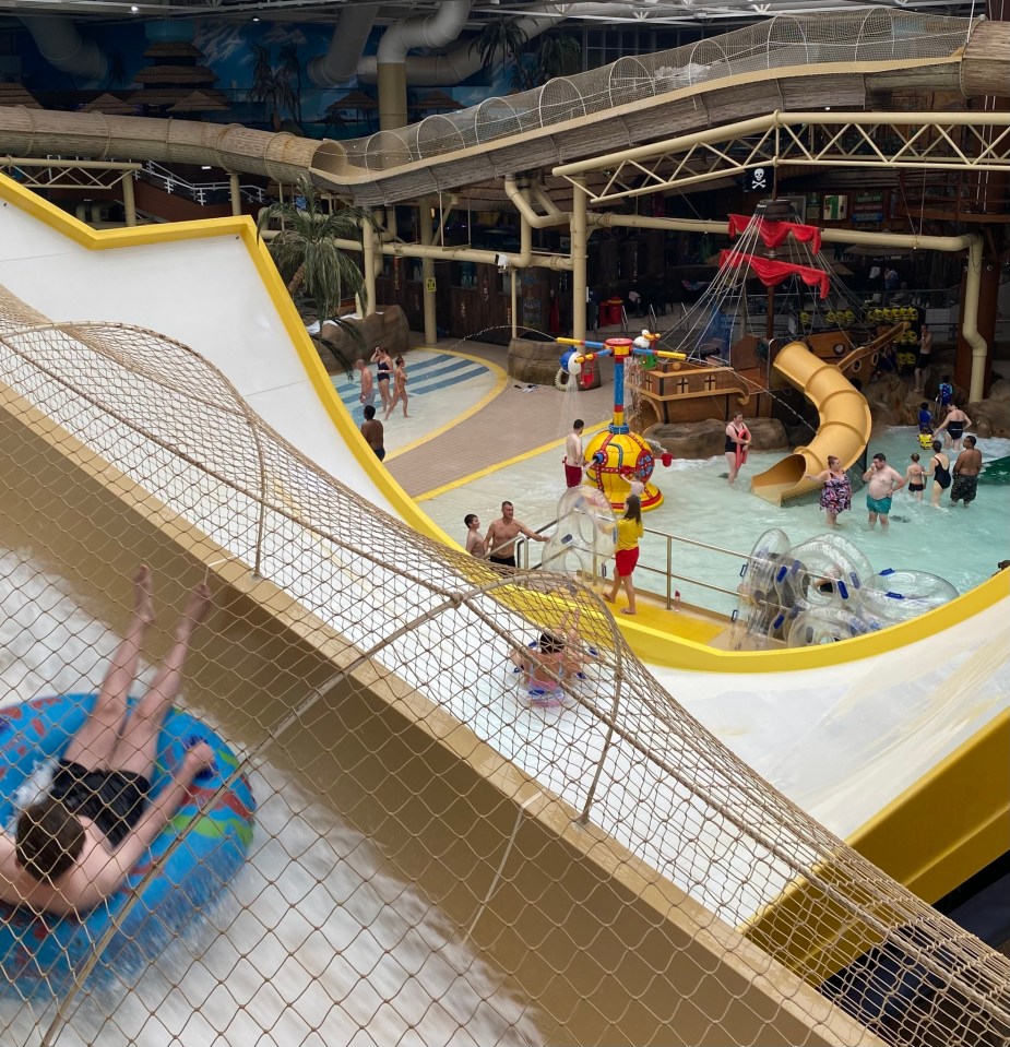 people are playing in a water park with a pirate ship in the background