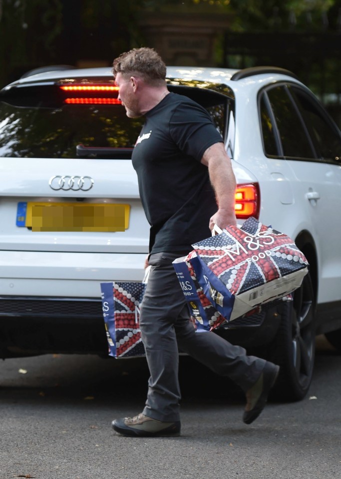 a man carrying a bag that says m & s on it