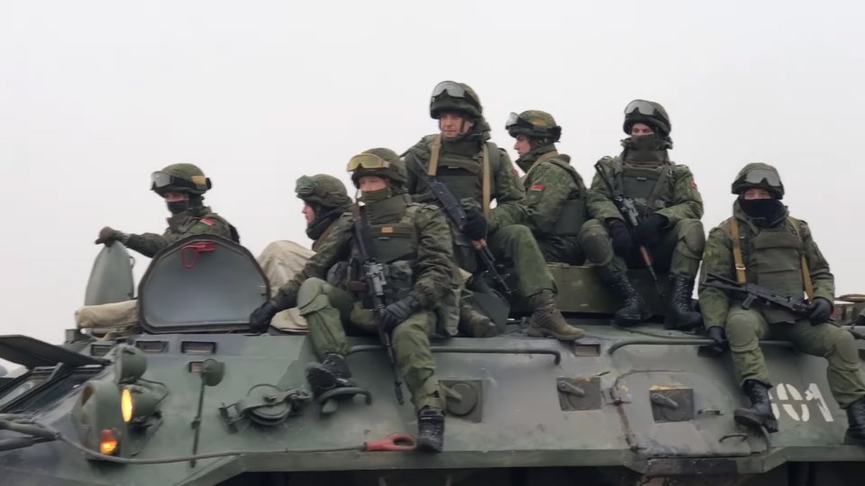 a group of soldiers are sitting on top of a vehicle with the number 04 on it